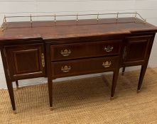 A Sheraton style sideboard with raised brass gallery back, flanked with cupboards and drawers (H90cm