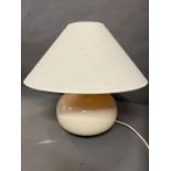 A contemporary cream table lamp