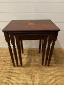 A nest of three tables with inlaid top on turned legs