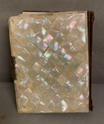 An antique pearlized and brass photo bound album containing a large selection of family portraits