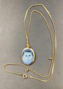 A 9ct gold necklace and pendant with cat image. (Approximate Total Weight 5.5g)
