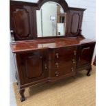 A mahogany sideboard, the arched mirror back flanked by panelled sides, on a breakfront base with