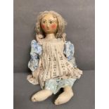 A vintage doll with a wooden hand painted face