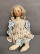 A vintage doll with a wooden hand painted face