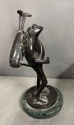 A cast metal frog with golf club on his back on a marble base (H21cm)