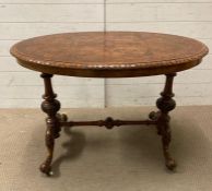 A burr walnut oval centre table (H72cm W106cm D68cm)