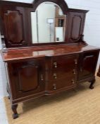 A mahogany sideboard, the arched mirror back flanked by panelled sides, on a breakfront base with