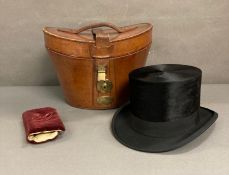 A Burton silk top hat in an antique leather and brass case, size 59 (Case strap in need of repair)