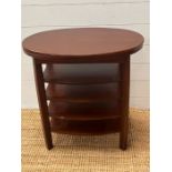 An oval side table with central shelves 60cm x 63cm