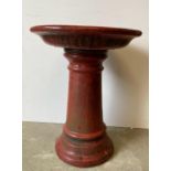 A red painted garden bird bath