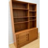 A Mid Century wall unit with six shelves and four drawers under with sliding door