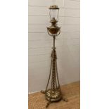 A Victorian brass floor standing oil lamp on four legs with foliate details