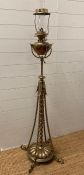 A Victorian brass floor standing oil lamp on four legs with foliate details
