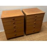 A pair of Schreiber five drawer bedside table on castors (H71cm W50cm D43cm)