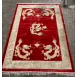 A red ground dragon motif silk rug