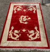 A red ground dragon motif silk rug