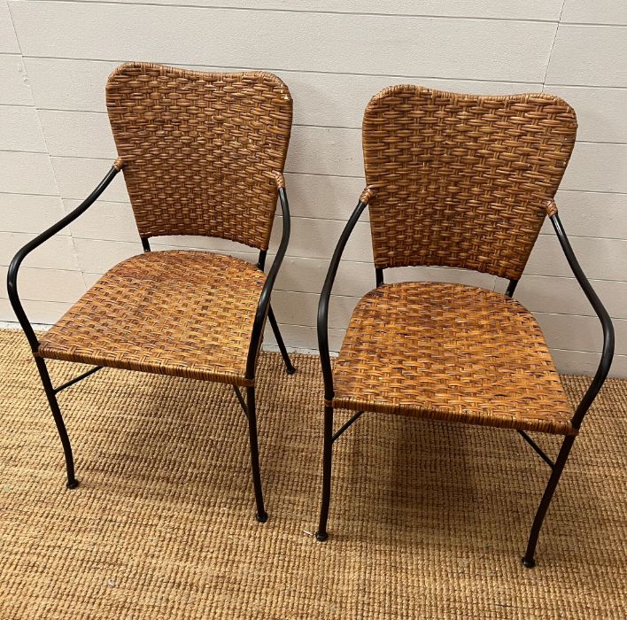 A pair of wicker side chairs with metal frame