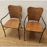 A pair of wicker side chairs with metal frame