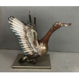 A metal sculpture of a duck taking flight