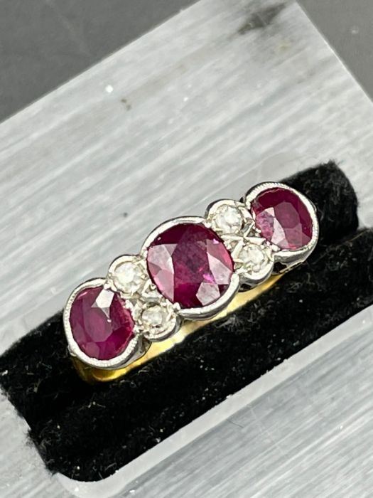 An Antique three stone ruby ring with four small diamonds. Size K - Image 2 of 4