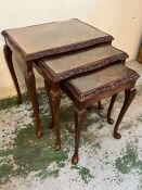 A nest of three mahogany glass top tables