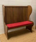 An oak vintage two seater settle with red upholstered cushions (H123cm W122cm Seat Depth 39cm)