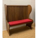 An oak vintage two seater settle with red upholstered cushions (H123cm W122cm Seat Depth 39cm)