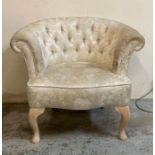 A white upholstered button back bedroom chair