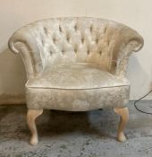 A white upholstered button back bedroom chair