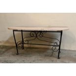 A wrought iron coffee table with polished marble top