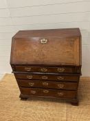 A George III bureau in two pieces, the fall front enclosing drawers and recesses around a central