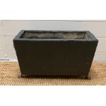 A dark grey painted wooden planter with lion heads handles on lion paw feet (H29cm W49cm D22cm)