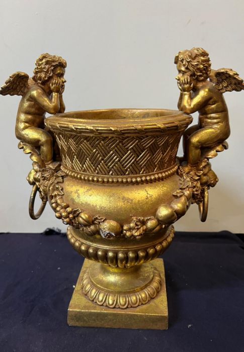 A gilt vase with cupids to side