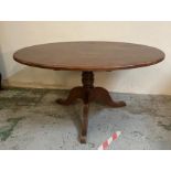 A mahogany oval pedestal dining table on tripod legs (H77cm W120cm D50cm)