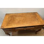 An early 19th Century fruit wood provincial desk having an arrangement of five drawers on slight