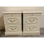 A pair of white bedside tables with brass effect handles