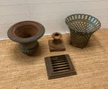 A selection of cast iron garden items to include a planter or urn and a pierced basket