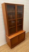 A glazed teak bookcase with cupboard under by Turnbridge of London (H176cm W90cm D43cm)