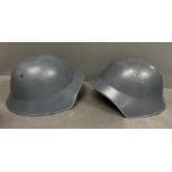 Two metal military helmets with leather interior
