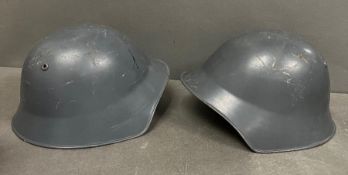 Two metal military helmets with leather interior