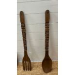 A large wooden spoon and fork wall hanging
