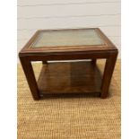 A square coffee table with glass and rattan top