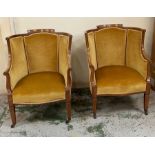 A pair of easy salon chairs inlaid, scrolling arms and tapering legs