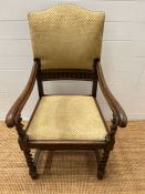An oak elbow chair with barley twist front supports and upholstered seat pads