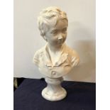 A bust of a boy on a marble base signed Houdon 1875