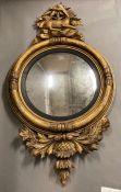 A Regency oval convex mirror in an gilt frame with reclining deer, with silvered finish in