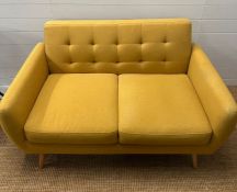 A Mid Century style mustard upholstered two seater button back sofa