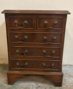 A small mahogany chest of drawers with two short over three graduated drawers and drop handles (