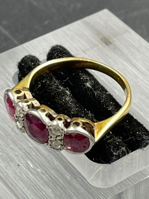 An Antique three stone ruby ring with four small diamonds. Size K - Image 3 of 4