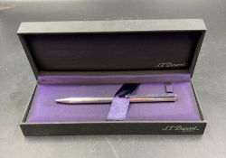 An S T Dupont of Paris biro in gold metal with paper, along with a silver metal S T Dupont biro,